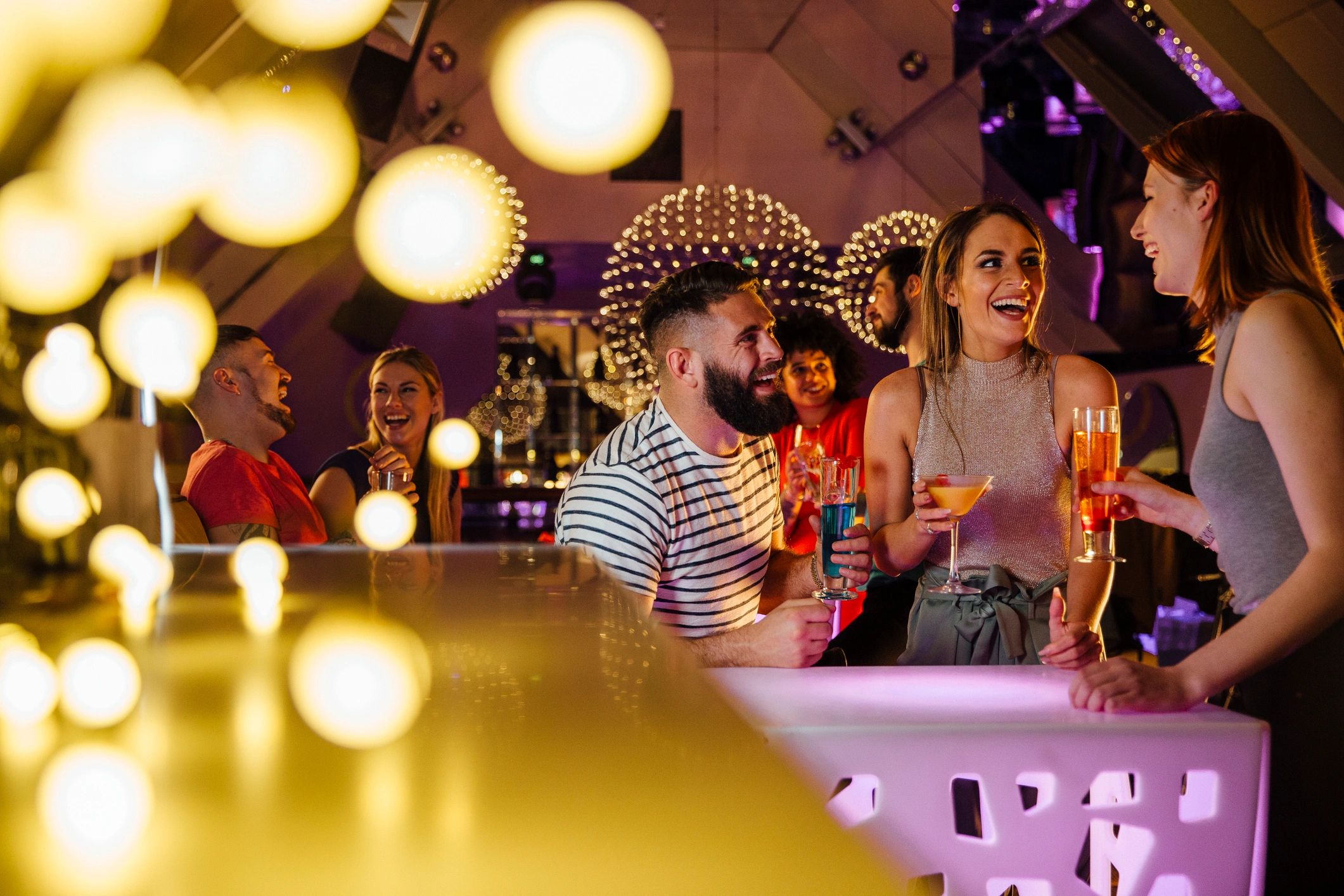 Friends enjoying cocktails in a nightclub